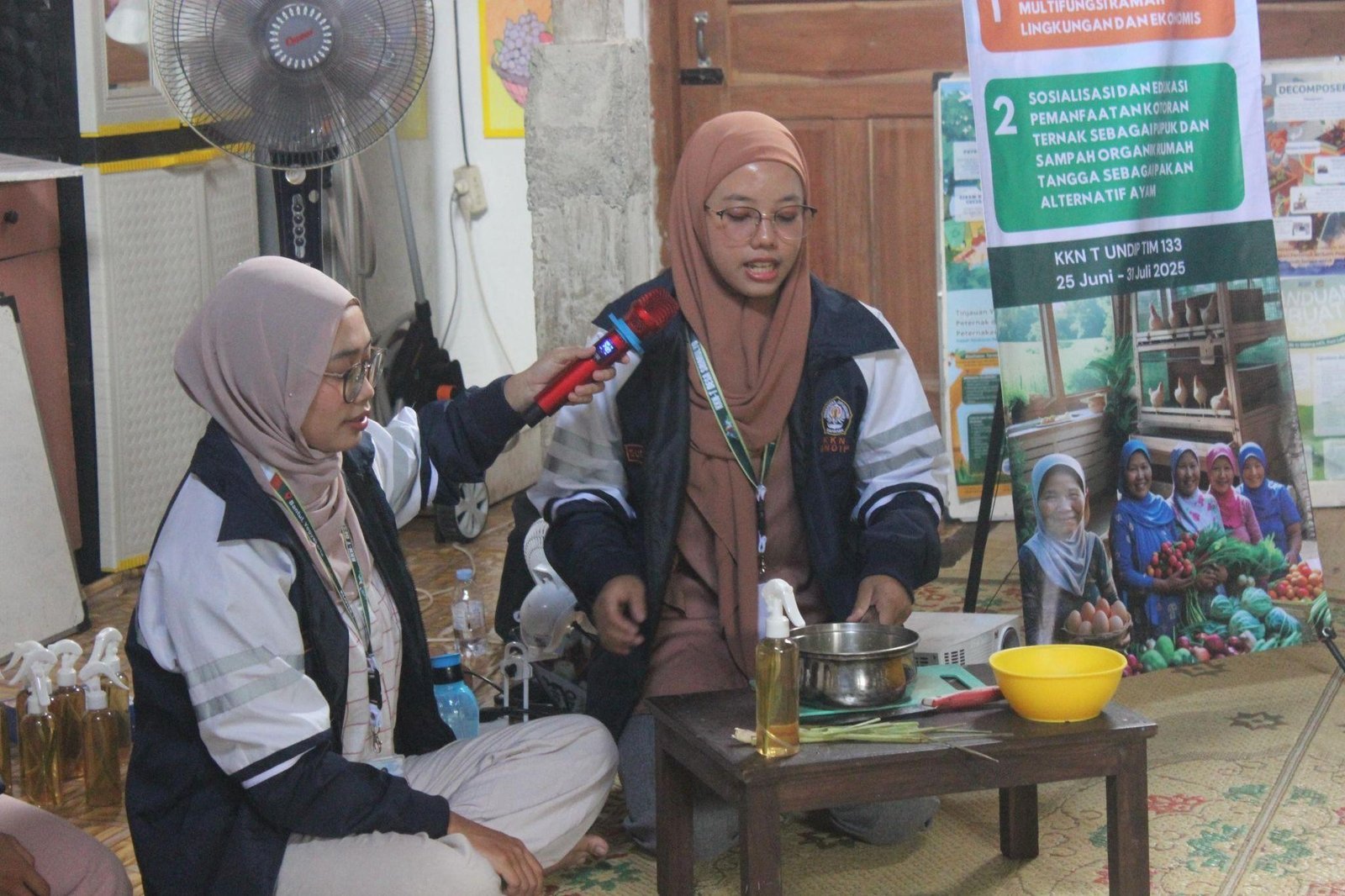 Mahasiswi KKN UNDIP, Fathma Candra dan Suci Amara, tengah memberikan edukasi dan mempraktikkan pembuatan desinfektan alami di depan para warga Dusun Onggopatran (sumber: dokumentasi pribadi).
