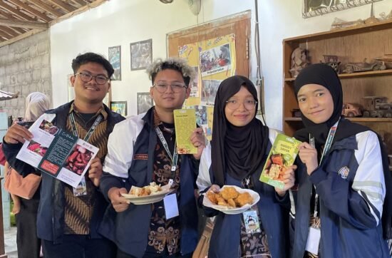Mahasiswa KKN-T Tim 133 Saintek Kelompok 2 menunjukkan hasil produk dari demonstrasi masak berupa nugget sayur dan ekado yang diolah dari bahan ikan serta brosur penjelasan sosis daging merah dan muffin omelet sayur. (Sumber: Dokumentasi Pribadi).