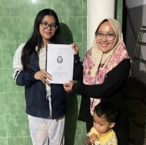 Mahasiswa KKN-T UNDIP Tim 133, Eirene Laura (Administrasi Publik) menyerahkan hasil output berupa “Draft Rencana Tindak Lanjut Program Intervensi Gizi: Gerakan 1 Hari 1 Telur” kepada Ibu Prapti selaku Dukuh di Dusun Onggopatran. (Sumber: Dokumentasi Pribadi)